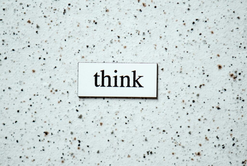 Minimalist photo featuring the word 'think' on a textured background, inspiring contemplation.