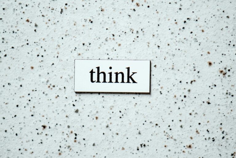 Minimalist photo featuring the word 'think' on a textured background, inspiring contemplation.