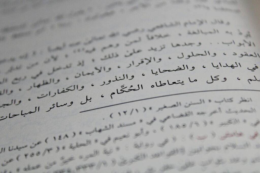 Close-up view of Arabic script on a book page, showcasing detailed calligraphy and text arrangement.