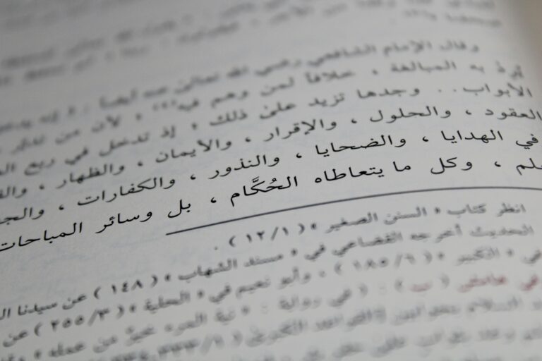 Close-up view of Arabic script on a book page, showcasing detailed calligraphy and text arrangement.